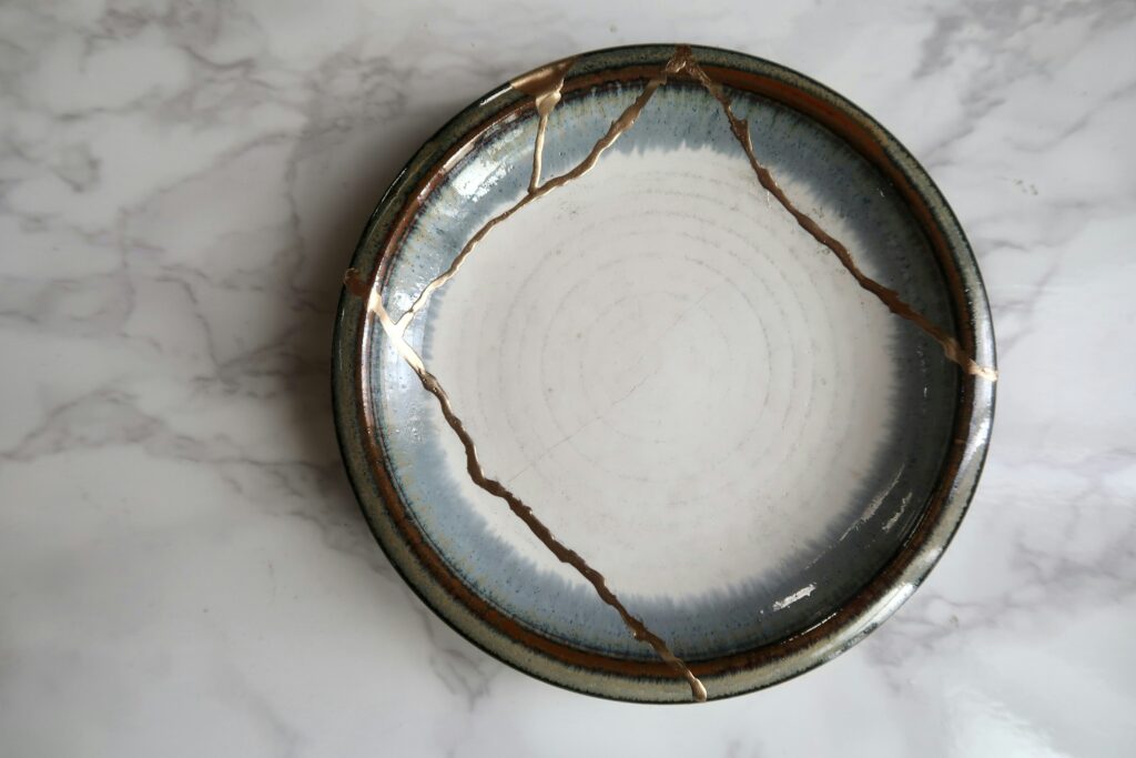 A broken ceramic bowl repaired with gold seams in the Japanese kintsugi style