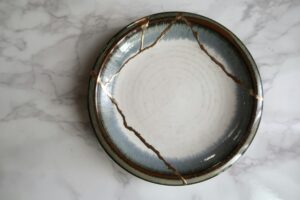 A broken ceramic bowl repaired with gold seams in the Japanese kintsugi style
